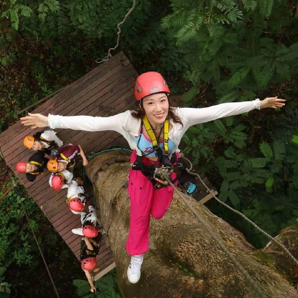 Zipline rider soaring over the rainforest canopy at Hanuman World Phuket